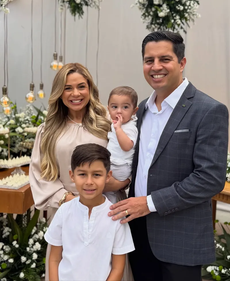 Reny, Thiago, o Théo e o Davi juntos, sorrindo, com o Davi no colo
