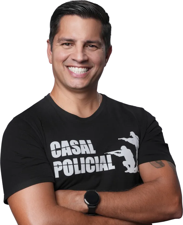 Thiago de braços cruzados, sorrindo, com a camiseta do Casal Policial